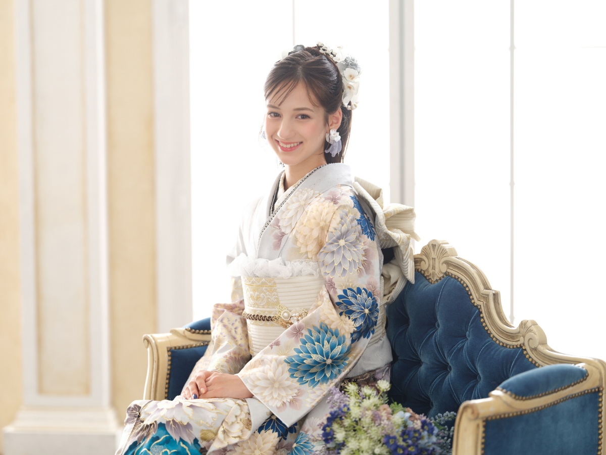 白い生地に青い花柄の振袖を着た成人女性